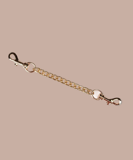 Liebe Seele Boudoir Amor Vegan Enkelboeien – Zwart Pair of Liebe Seele Boudoir Amor black ankle cuffs connected by a gold-tone chain.