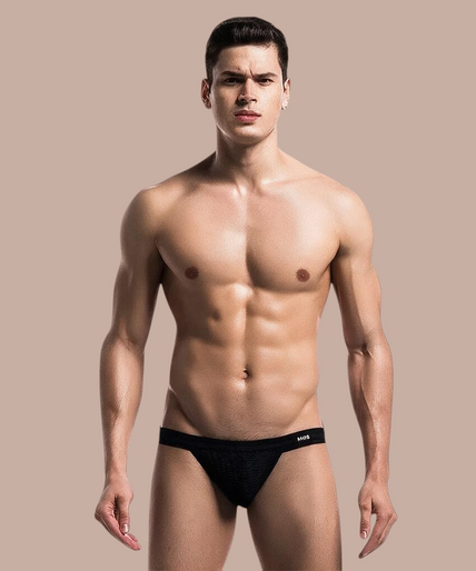 Mob – Fetisch Jockstrap Badeanzug Schwarz Größe S Model draagt een zwarte Pleasurements MOB jockstrap met een sportief en sensueel ontwerp.