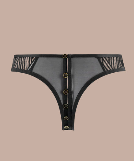Atelier Amour – Clair Obscur Open Tanga Black Model wearing black geometric lace tanga and underwired bra, angled front view with hand on hip.