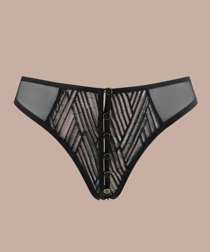 Atelier Amour – Clair Obscur Open Tanga Black Model wearing black geometric lace tanga and underwired bra, angled front view with hand on hip.