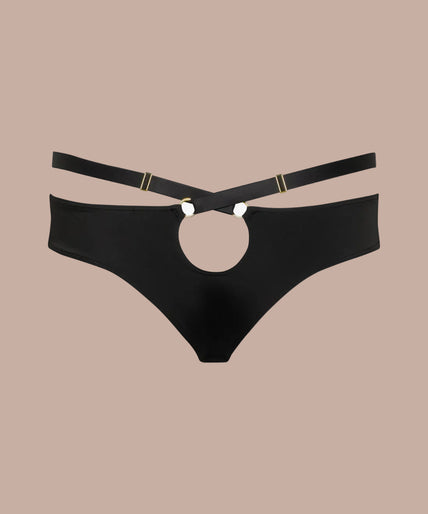 Maison Close – Fatale Tanga Zwart – Lingerie & Bikini / Badkleding Model wearing black Fatale tanga with a raised waist strap and matching crossed-strap bra, side view.