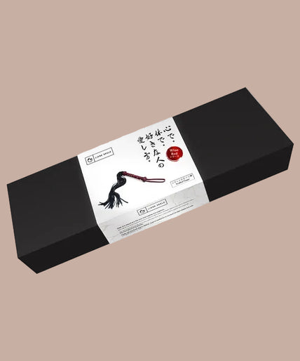 Liebe Seele Heavy Leather Flogger met Handvat met Noppen – Wijnrood Flogger with black falls, wine-red studded handle and wrist loop, curved arrangement.