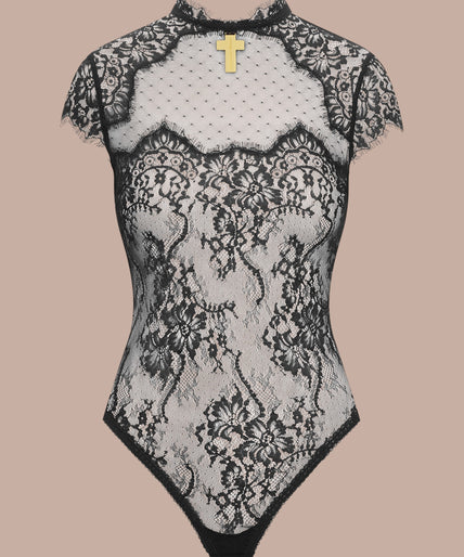 Maison Close/Scandale โ Inspiration Divine Open Back Lace Thong Body Black Inspiration Divine black Open Back Lace Thong Body with sheer floral lace and a gold-tone cross at the collar, front view on model.