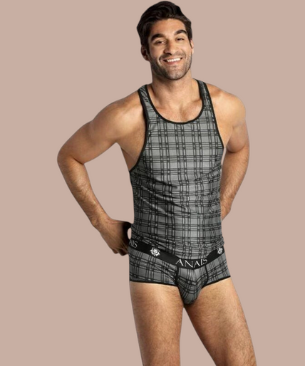 Anais Men – Balance Top S Pleasurements Anais Men Balance Top in grijs met ruitpatroon, gedragen door een glimlachend model.