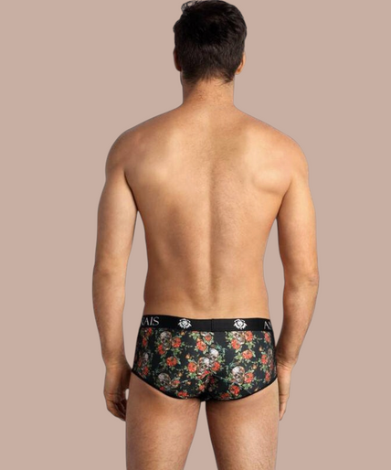 Anais Men – Power Brief | Premium Men’s Underwear Model draagt Anais Men Power Brief met bloemenprint en Pleasurements merklogo op de zwarte tailleband.