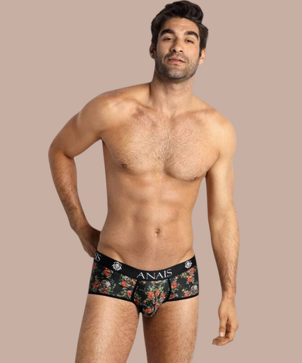 Anais Men – Power Brief | Premium Men’s Underwear Model draagt Anais Men Power Brief met bloemenprint en Pleasurements merklogo op de zwarte tailleband.