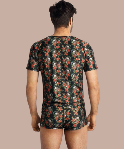 Anais Men – Power T-Shirt S Pleasurements Anais Men Power T-shirt met zwart, rood en wit schedel- en rozenpatroon gedragen door een lachend model