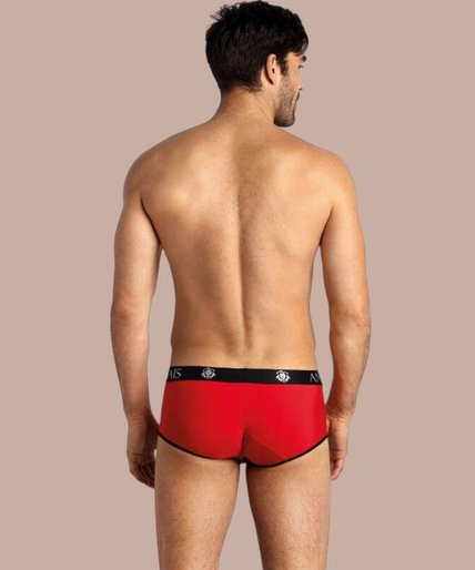 Anais Men – Soul Brief | Premium Men’s Underwear Pleasurements Anais Men Soul Brief in rood met zwarte tailleband en logo, gedragen door een glimlachend model.