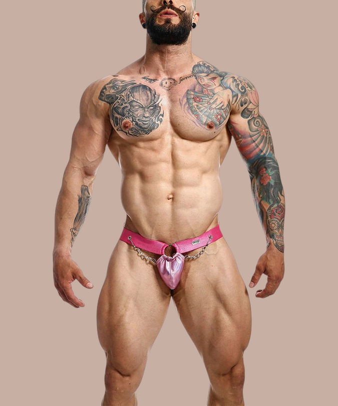 Pleasurements Mob Dngeon jockstrap in roze leer en metaal met kettingdetail gedragen door een gespierd model