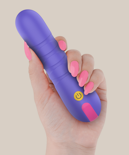 Pleasurements – Intensiv – Stella Stoßvibrator Pleasurements Stella paarse siliconen vibrator met stuwende functie vastgehouden in een hand