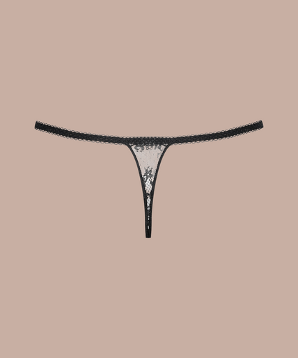 Inspiration Divine black Thong with sheer dotted mesh, floral lace and narrow side straps, front view on model.