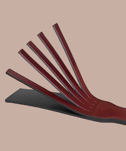 Liebe Seele wine-red split tawse paddle with stitched edges, a narrow handle and a hanging cord.