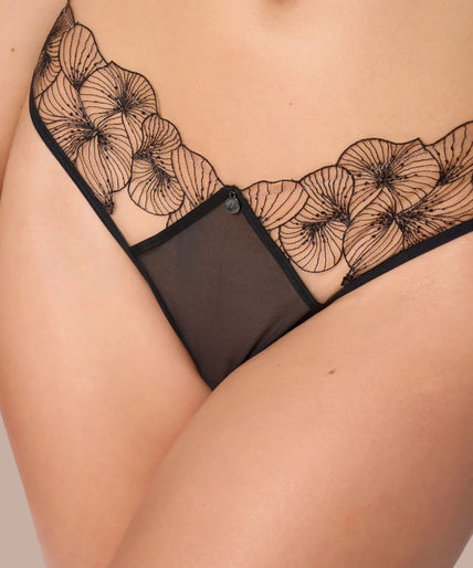 Model wearing black Menu Plaisir tanga with sheer floral waistband and matching triangle bra, front view.