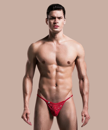 Model draagt een rode kanten MOB thong van Pleasurements met een minimalistisch en sensueel ontwerp.