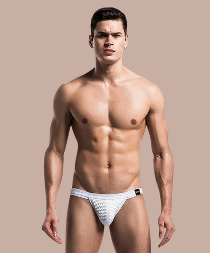 Pleasurements witte MOB jockstrap zwemkleding met textuur voor heren gedragen door een model.