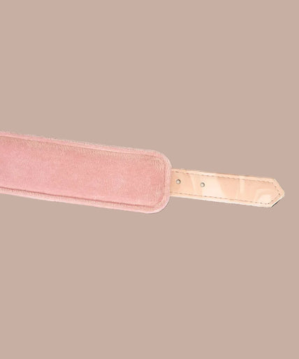 Angled view of Liebe Seele Boudoir Amor blush pink wrist cuffs showing buckles, lining and connector chain.