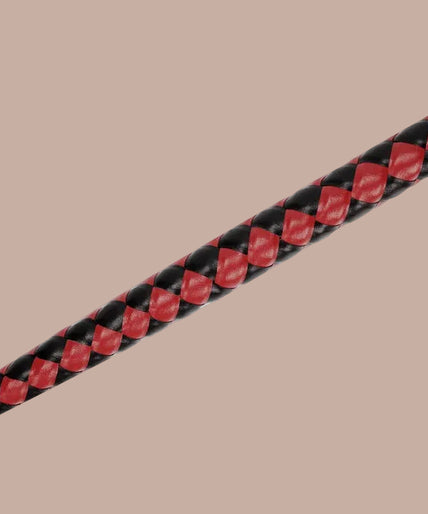 Red and black braided bull whip with black split tip, arranged vertically in a curve.
