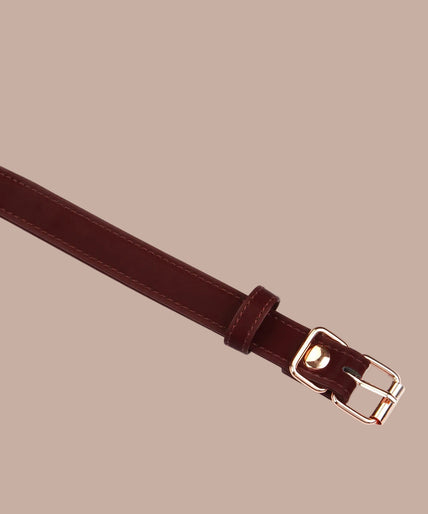 Dark red blindfold with stitched edges and adjustable buckle strap, front view.