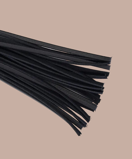 Flogger with black falls, wine-red studded handle and wrist loop, curved arrangement.
