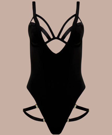 Side view of model wearing black Fatale bodysuit with strappy neckline and high-cut legs, one arm raised.
