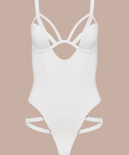 Model wearing white Fatale bodysuit with strappy neckline and high-cut legs, both arms raised.