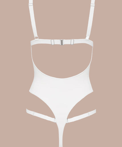 Model wearing white Fatale bodysuit with strappy neckline and high-cut legs, both arms raised.