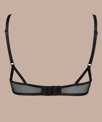 Model wearing black Menu Plaisir embroidered balconette bra and matching thong, one hand beside her head.