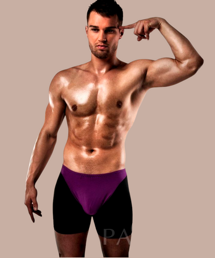 Pleasurements Passion Boxer 009 in lila en zwart gedragen door een gespierd model tegen een witte achtergrond