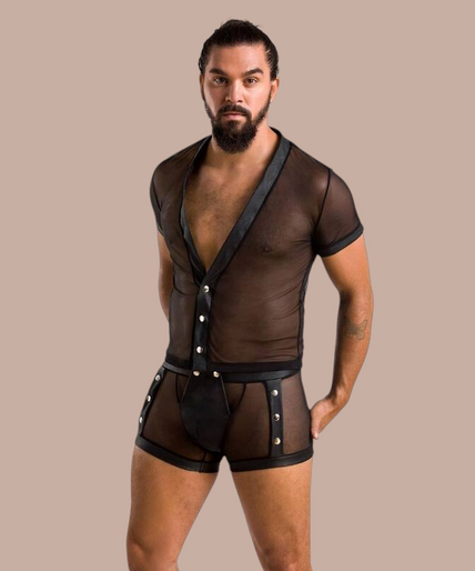 Man met baard draagt Pleasurements Passion 052 Michael set, een zwart doorschijnend ondergoedsetje met drukknopen.