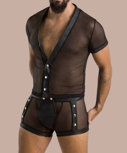 Man met baard draagt Pleasurements Passion 052 Michael set, een zwart doorschijnend ondergoedsetje met drukknopen.