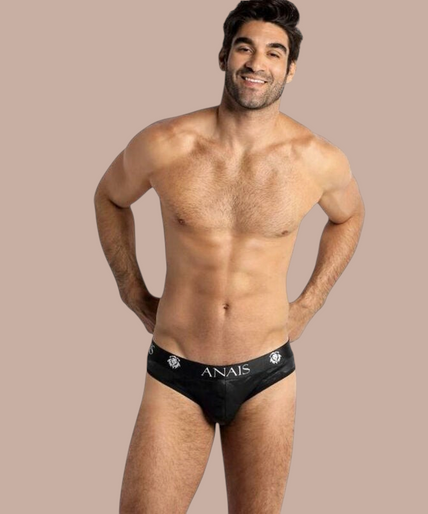Model draagt zwarte Anais Men Electro Slip herenonderbroek met merklogo op de tailleband van Pleasurements