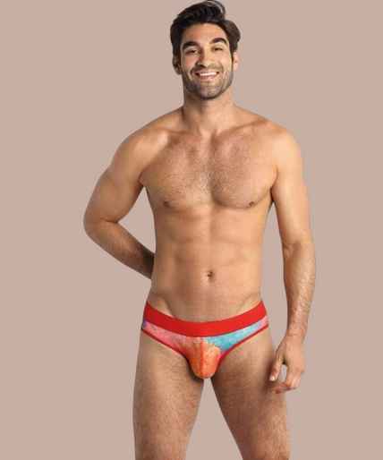 Pleasurements Anais Men Falcon slip met kleurrijk tie-dye patroon en rode tailleband gedragen door een model