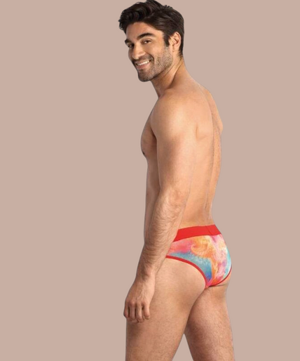 Pleasurements Anais Men Falcon slip met kleurrijk tie-dye patroon en rode tailleband gedragen door een model