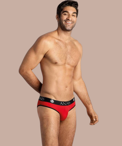 Pleasurements Anais Men Soul Slip in rood met zwarte tailleband gedragen door een glimlachend model