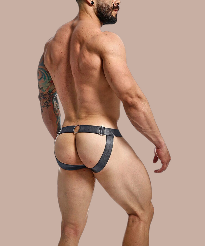Pleasurements Mob Dngeon grijze leren jockstrap met metalen ringen gedragen door een gespierde man