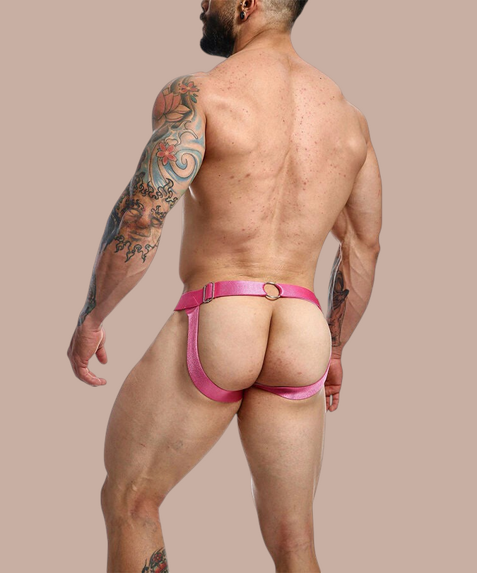 Pleasurements Mob Dngeon jockstrap in roze leer en metaal, gedragen door een gespierd model van achteren gezien.