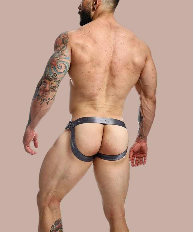 Pleasurements Mob Dngeon grijze leren jockstrap met metalen drukknopen gedragen door een gespierde man