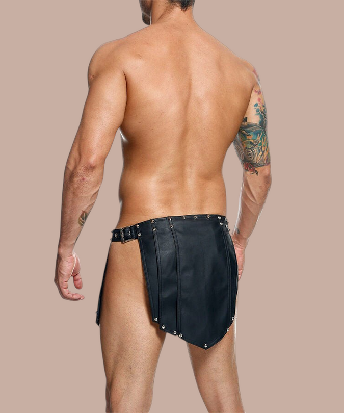 Pleasurements Mob Dngeon zwarte leren rok met metalen studs gedragen door een man voor een verfijnde uitstraling.