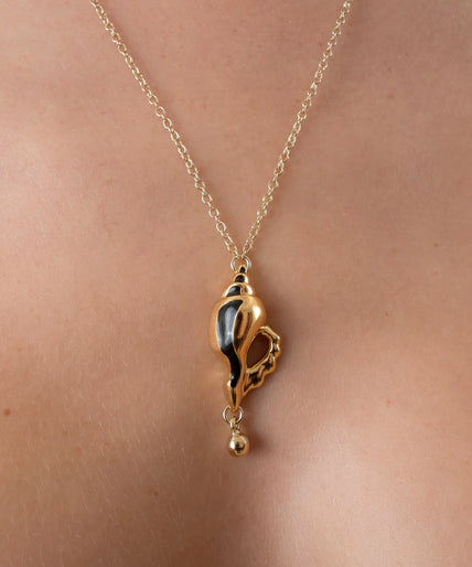 Sylvie Monthulé Secret Passion gold-coloured shell pendant with black accents and a dangling bead on a chain.