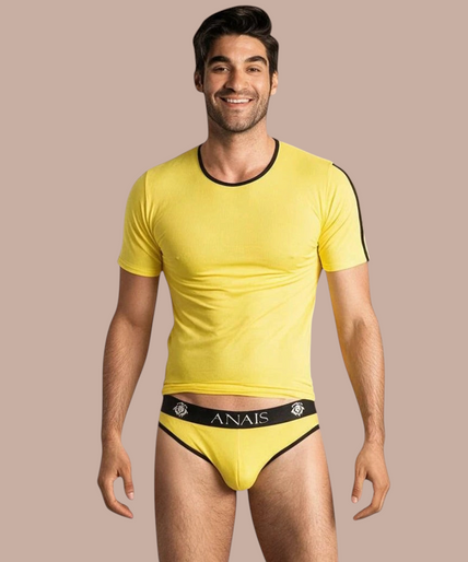 Pleasurements Anais Men Tokio T-shirt in geel met zwarte accenten gedragen door een glimlachend model